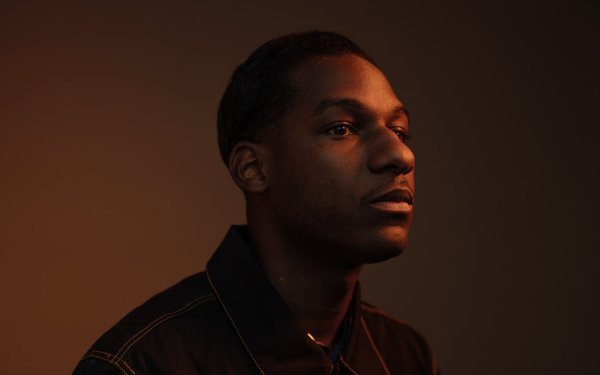 High-definition desktop wallpaper featuring a silhouette profile view of a man with soft lighting on his face against a neutral background, tagged with Leon Bridges.
