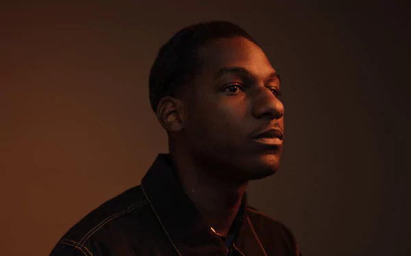 High-definition desktop wallpaper featuring a silhouette profile view of a man with soft lighting on his face against a neutral background, tagged with Leon Bridges.