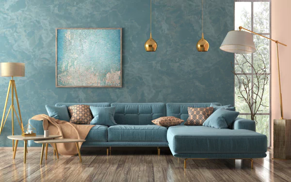 HD desktop wallpaper of a modern living room featuring a stylish man-made blue sofa, decorative pillows, pendant lights, and contemporary furniture against a textured wall.