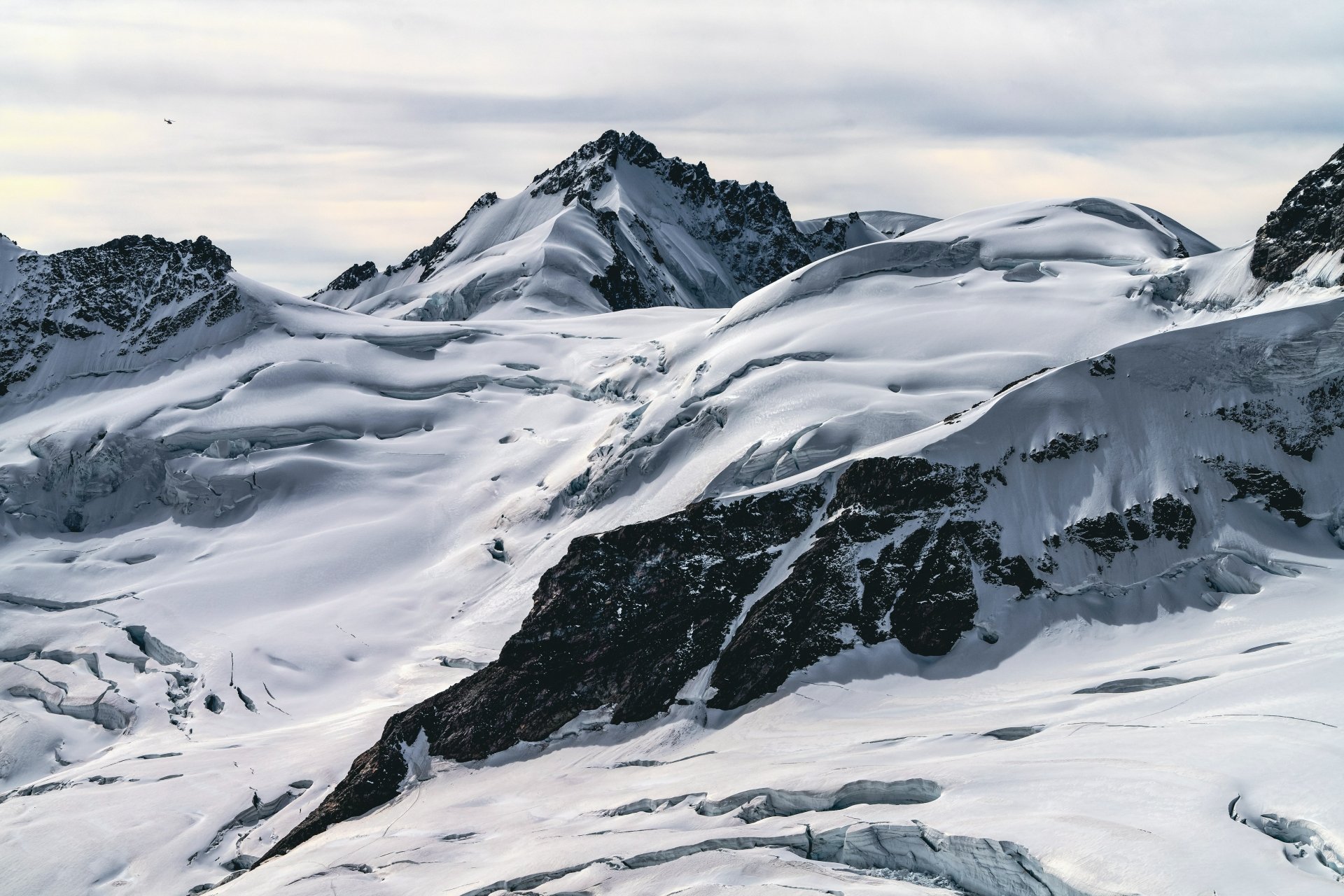 Snow-covered mountain peaks under a cloudy sky, showcasing natural beauty in a 4K Ultra HD snow and nature landscape.