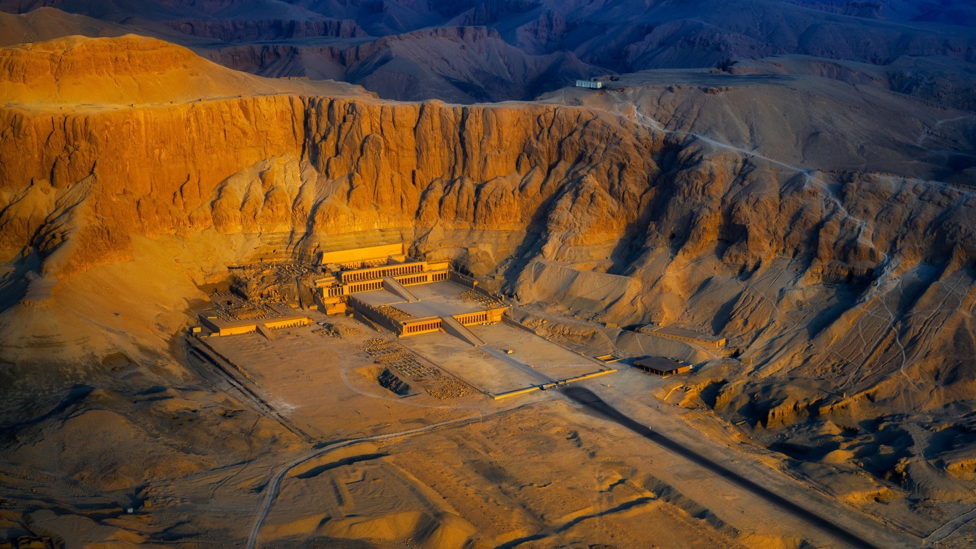 8K Ultra HD desktop wallpaper — aerial view of the Mortuary Temple of Hatshepsut, a monumental religious temple set in sunlit cliffs.