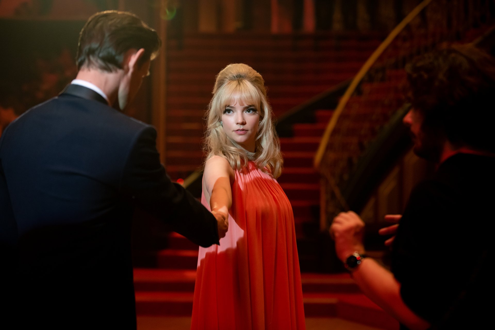 4K Ultra HD PC wallpaper from Last Night in Soho: blonde woman in a flowing red dress reaches toward a man in a suit on a grand staircase under warm, cinematic lighting.