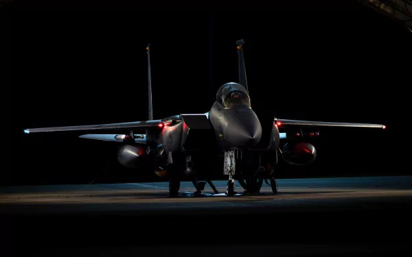 Front view of a McDonnell Douglas F-15 Eagle jet fighter warplane illuminated against a dark background, presented in 4K Ultra HD as a PC desktop wallpaper.