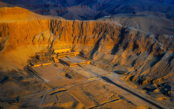 8K Ultra HD desktop wallpaper — aerial view of the Mortuary Temple of Hatshepsut, a monumental religious temple set in sunlit cliffs.