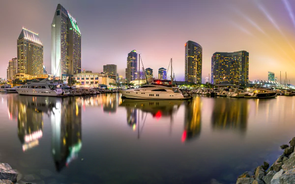 4K Ultra HD view of San Diego’s man-made marina at dusk, featuring yachts and city skyline reflected in the calm water.