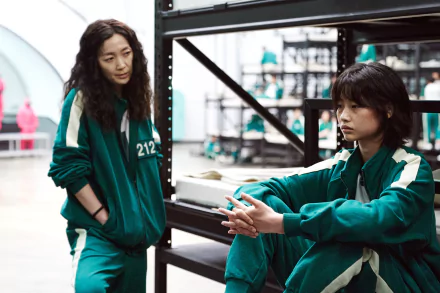 HoYeon Jung in a scene from the TV show Squid Game, featured in a 4K Ultra HD PC desktop wallpaper with characters in green tracksuits.