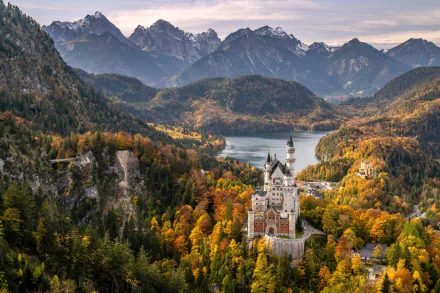 Man-made Neuschwanstein Castle amid autumn forests and lakes in the Bavarian Alps, Germany — 5K Ultra HD PC desktop wallpaper and background.