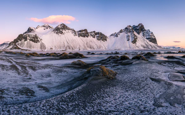 Snow-covered Vestrahorn mountain in Iceland at dusk, displayed in stunning 8K Ultra HD resolution showcasing rugged natural beauty and dramatic landscape.