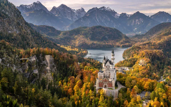 Man-made Neuschwanstein Castle amid autumn forests and lakes in the Bavarian Alps, Germany — 5K Ultra HD PC desktop wallpaper and background.