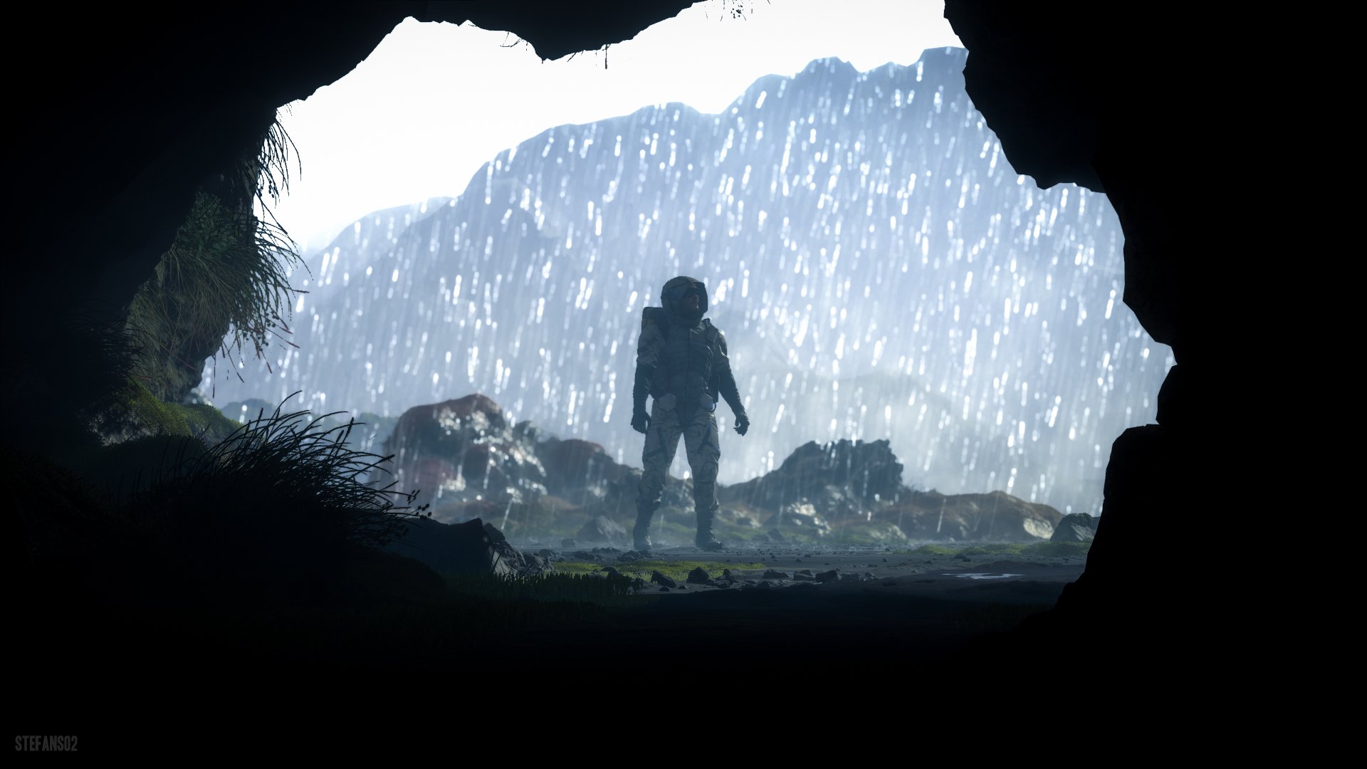 4K Ultra HD Death Stranding PC desktop wallpaper showing a silhouetted figure standing at a cave entrance, facing a rainy, rugged landscape.