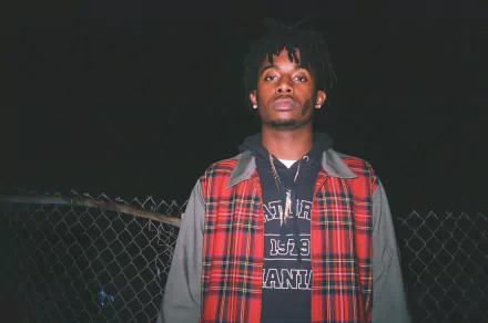 A striking HD desktop wallpaper featuring Playboi Carti, captured at night with a moody backdrop, showcasing his unique style and presence.