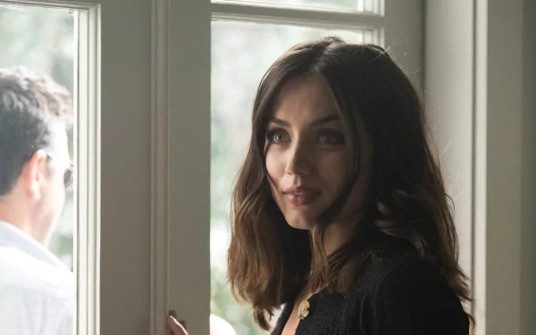 Close-up of a female actor from the movie Deep Water, standing by glass doors and looking toward a blurred man outside — 2K Quad HD PC desktop wallpaper.