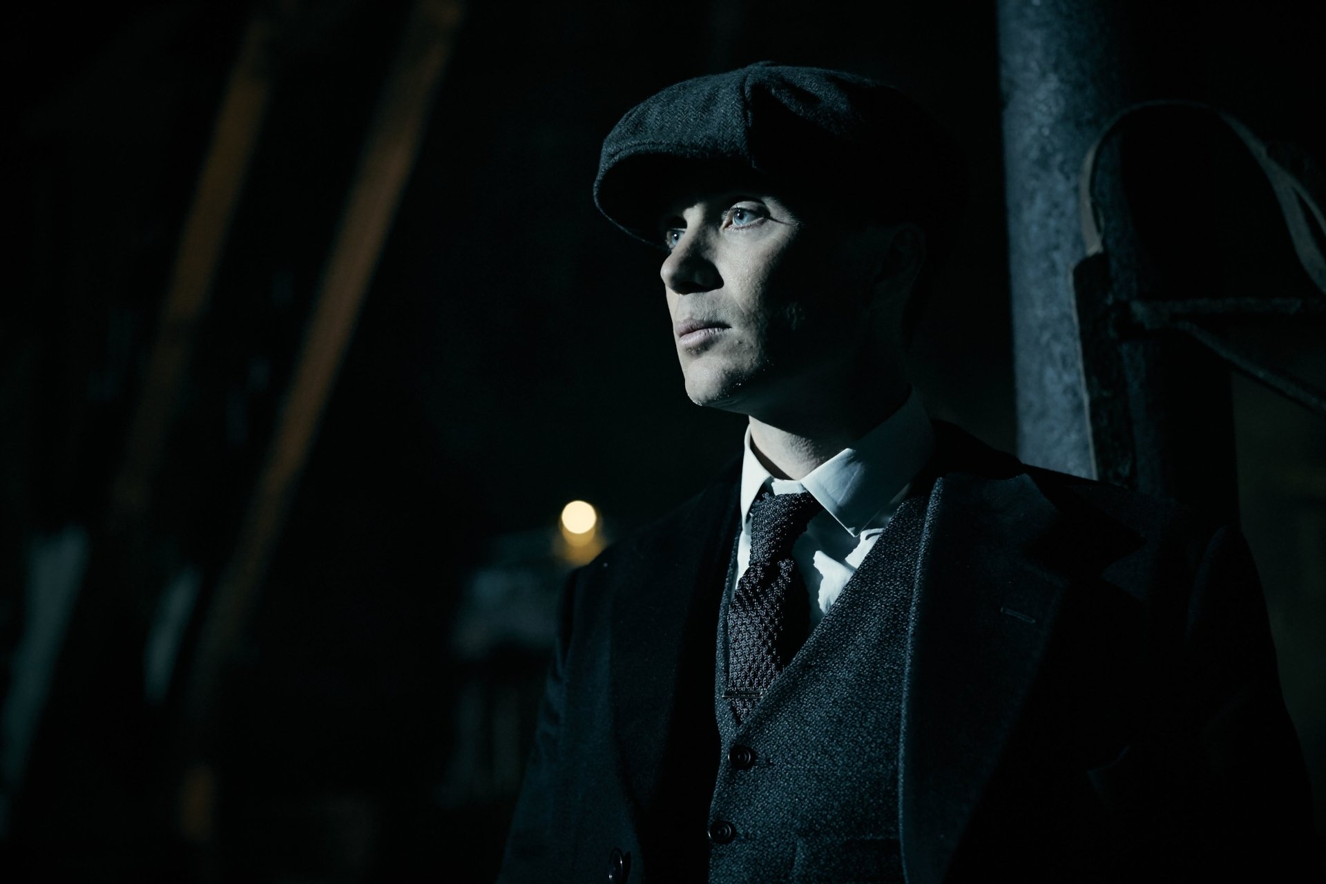 4K Ultra HD desktop wallpaper of a sharp-suited man in a newsboy cap, cinematic TV-show style portrait with dramatic side lighting and a moody 1920s period atmosphere.