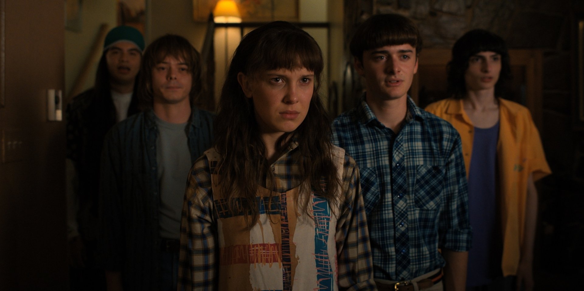 HD PC desktop wallpaper featuring main characters from the TV show Stranger Things standing together in a dimly lit room.