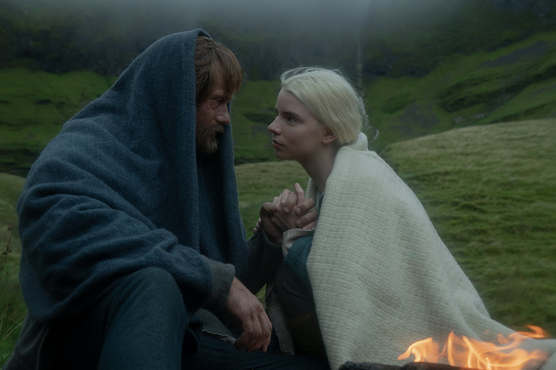 4K Ultra HD wallpaper featuring Alexander Skarsgård and Anya Taylor-Joy in a scene from the movie The Northman, set against a misty, green hillside background.