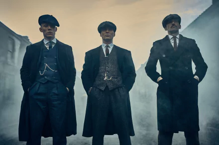 HD wallpaper of Cillian Murphy as Thomas Shelby from the TV show Peaky Blinders, featuring three men in period attire standing confidently in a misty street.
