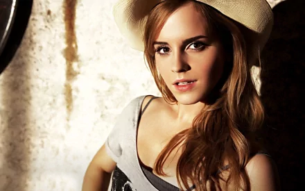 HD desktop wallpaper and background featuring Emma Watson, tagged as a Celebrity. Emma is wearing a hat with a relaxed expression against a textured backdrop.
