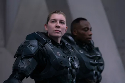 2K Quad HD PC desktop wallpaper from the Halo TV show: Kai-125 in dark combat armor standing alert beside a teammate inside a stark, futuristic interior.