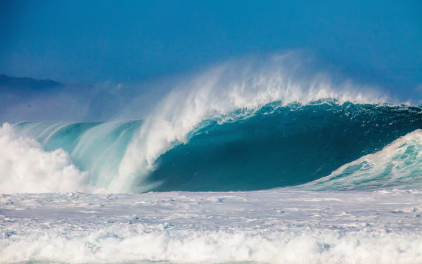 4K Ultra HD desktop wallpaper capturing a powerful ocean wave crashing under a clear blue sky, showcasing the dynamic beauty of nature.