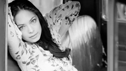 Black and white HD desktop wallpaper featuring a close-up portrait of celebrity Kristin Kreuk with a soft, contemplative expression.