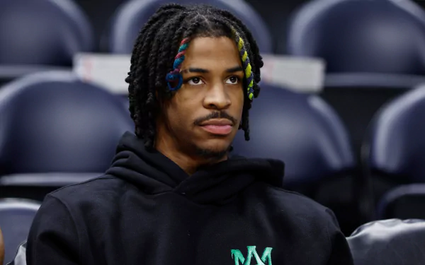 HD desktop wallpaper featuring basketball player Ja Morant in a black hoodie, captured in a candid moment during a sports event.