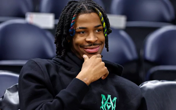HD PC desktop wallpaper featuring basketball player Ja Morant with colorful braided hair, smiling and seated in a sports arena.