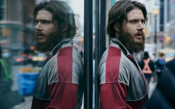 2K Quad HD desktop wallpaper: Soldier Boy (The Boys, 2019) — bearded man in a red jacket reflected in glass on a blurred city street.