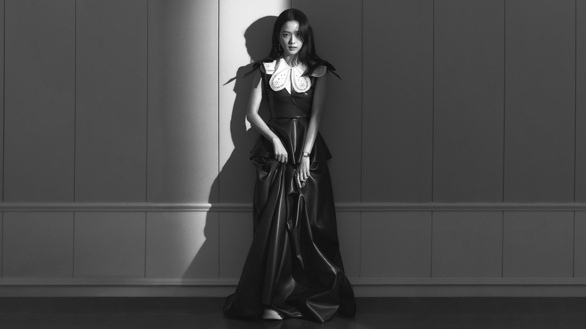 Black and white 4K Ultra HD wallpaper featuring a BlackPink member in a dramatic shadow, wearing a long dark dress with a white collar against a paneled wall.