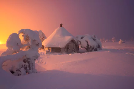 HD PC desktop wallpaper: snow-covered man-made hut and frosted trees bathed in warm sunset light in a quiet winter landscape.