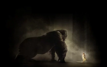 A dramatic scene from King Kong (2005) featuring the giant ape facing a tiny figure in an atmospheric setting, creating a striking HD desktop wallpaper.