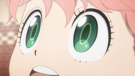 Close-up HD PC desktop wallpaper of Anya Forger from Spy x Family, her wide green eyes and excited expression filling the frame.