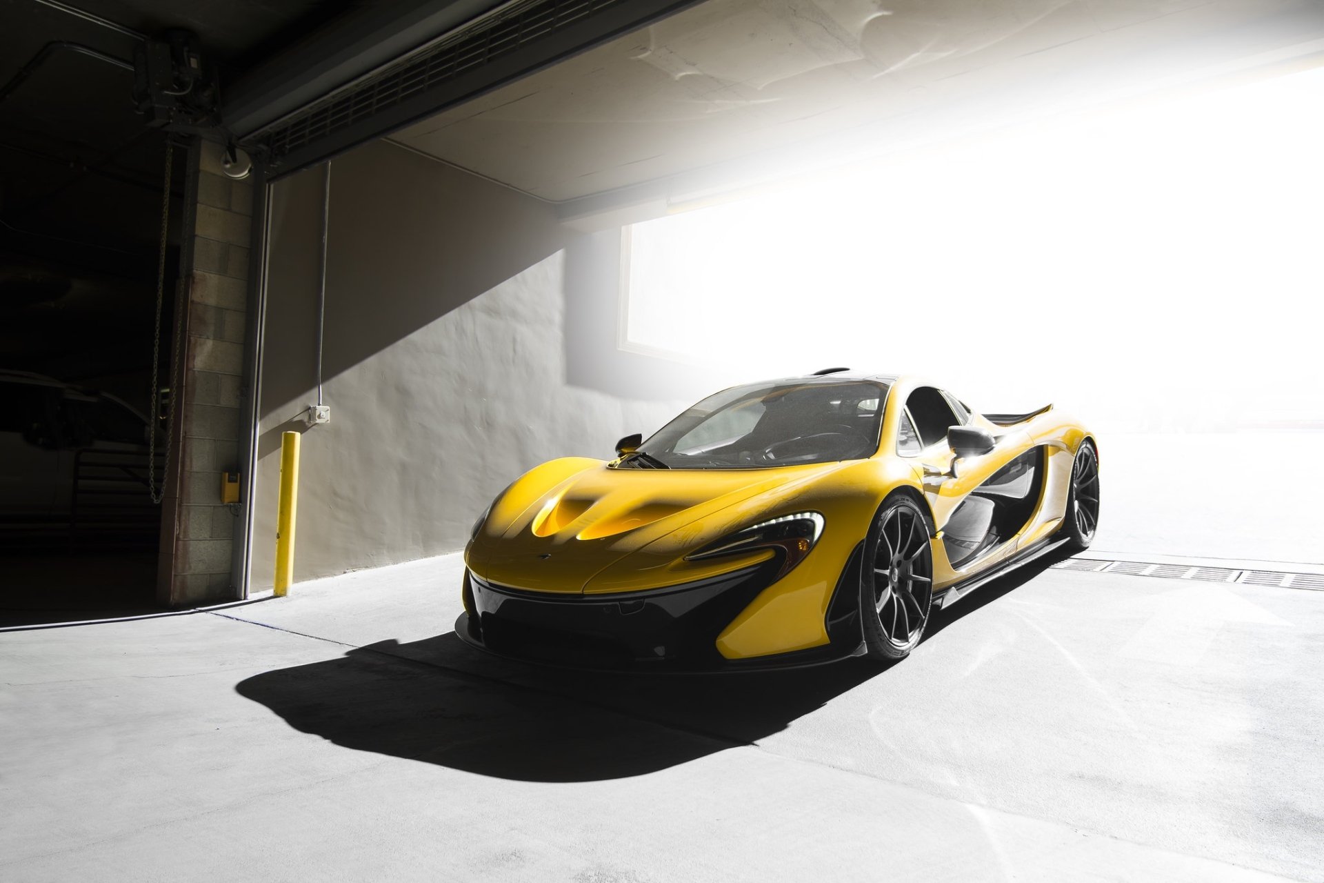 Yellow McLaren P1 vehicle in a sunlit garage — HD PC desktop wallpaper/background showcasing its sleek, aerodynamic lines.