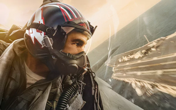 HD PC desktop wallpaper featuring a close-up of a pilot wearing a helmet from the movie Top Gun: Maverick, set against the backdrop of an aircraft carrier and sky.