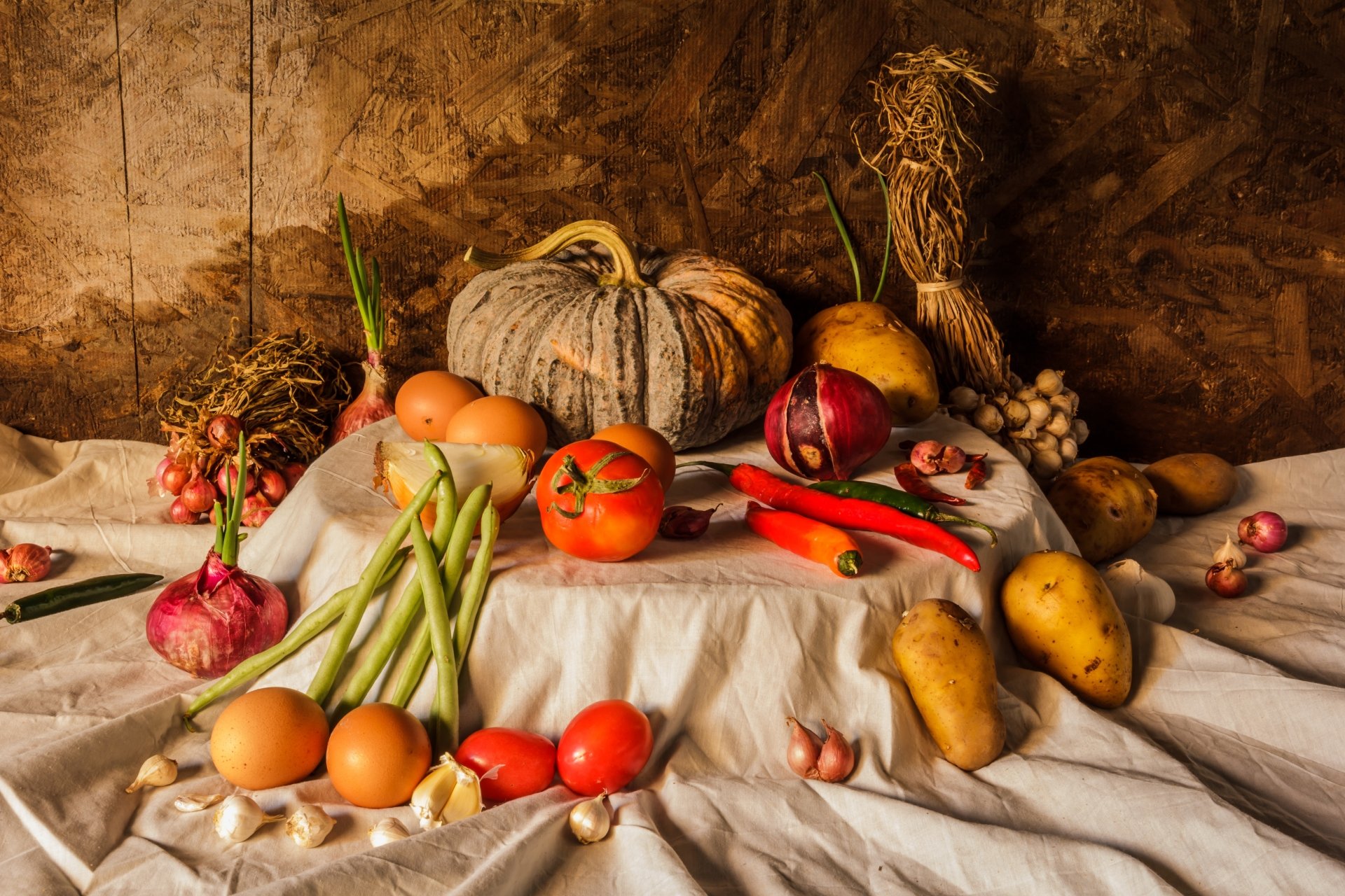 5K Ultra HD PC desktop wallpaper background - still life harvest of food: pumpkins, peppers, tomatoes, eggs, garlic and root vegetables on draped cloth.