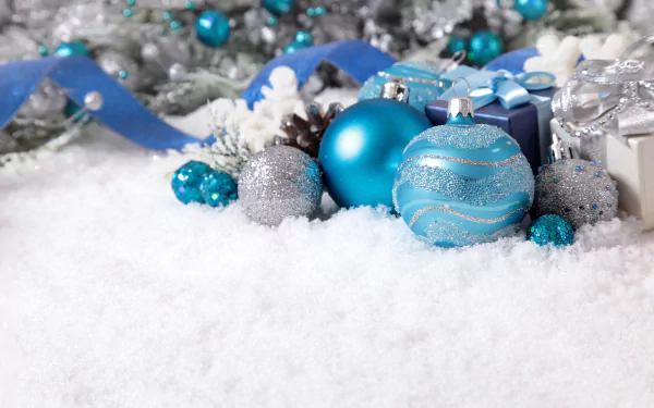 4K Ultra HD Christmas holiday desktop wallpaper featuring blue and silver ornaments, gift boxes, and ribbons resting on a bed of snow with festive silver decorations.
