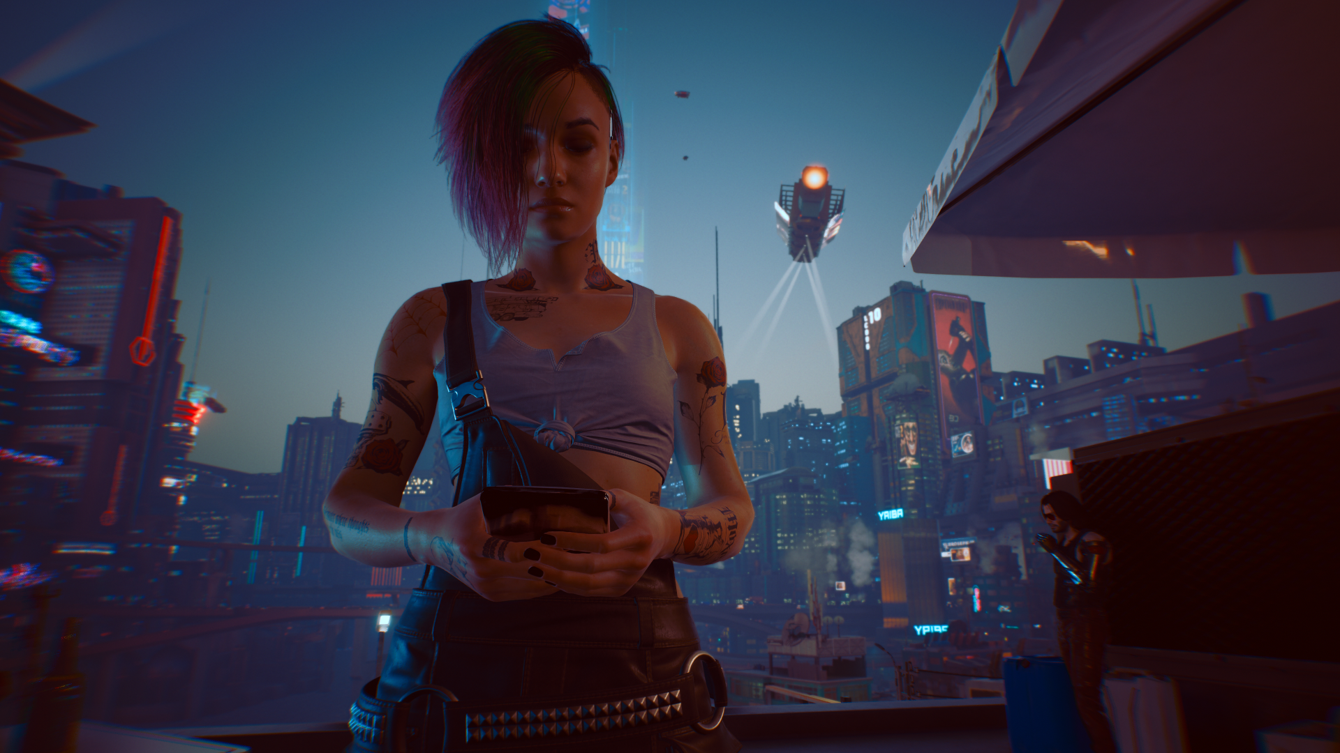 Judy (Cyberpunk 2077) on a neon-lit rooftop at dusk, holding a device as drones and a rain-slick futuristic city glow — HD PC desktop wallpaper background.