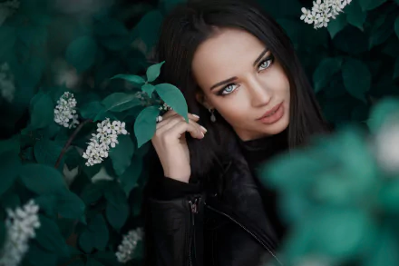 HD PC desktop wallpaper featuring a close-up of a woman, Angelina Petrova, with striking blue eyes surrounded by dark green foliage and white flowers.