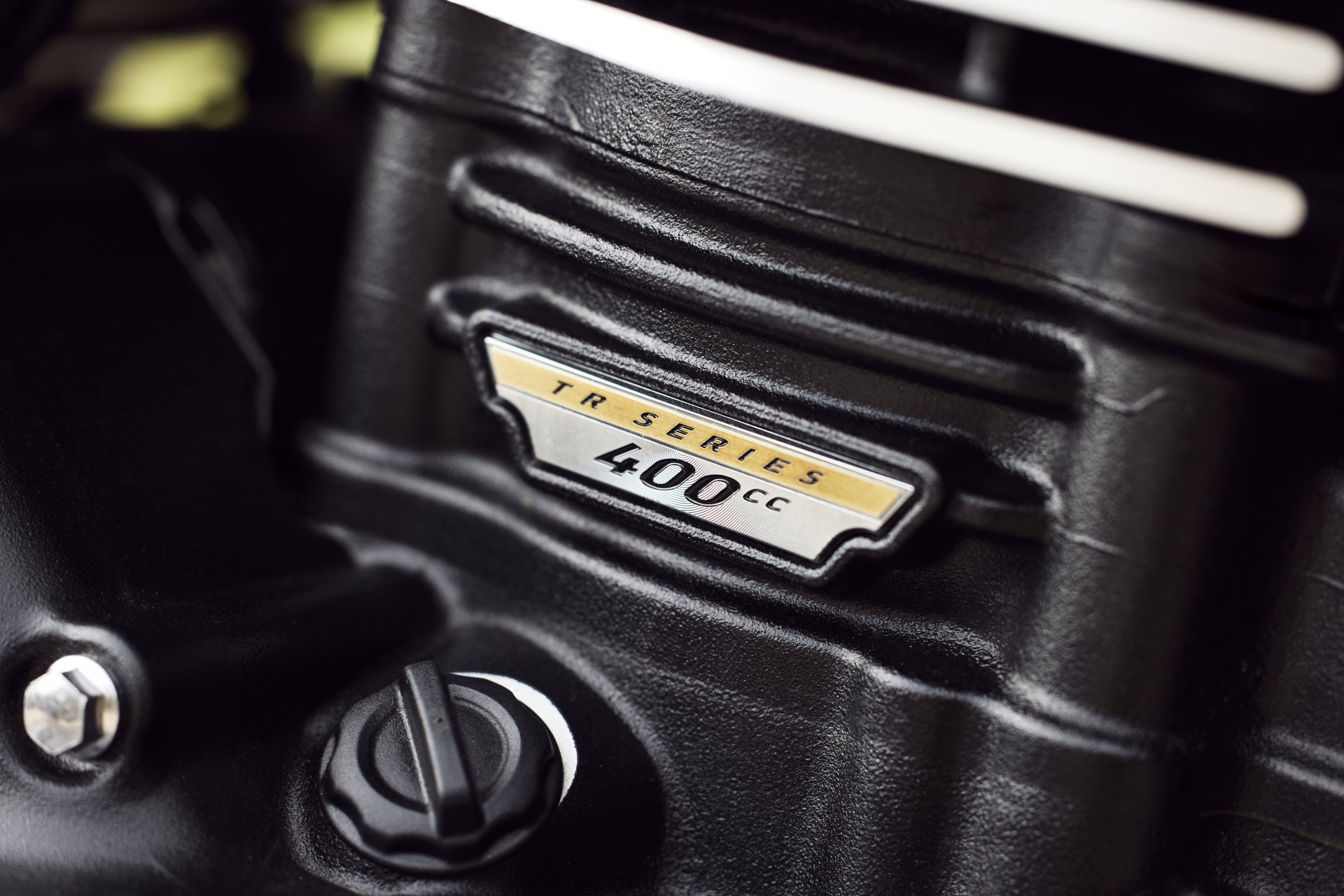 HD wallpaper of a close-up detail of a Triumph Scrambler 400 X engine, highlighting the 400cc badge.