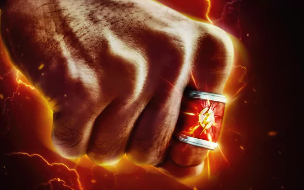 Close-up of a clenched fist wearing The Flash’s iconic red and gold ring, set against a fiery, lightning-filled background from The Flash (2023) 4K Ultra HD desktop wallpaper.