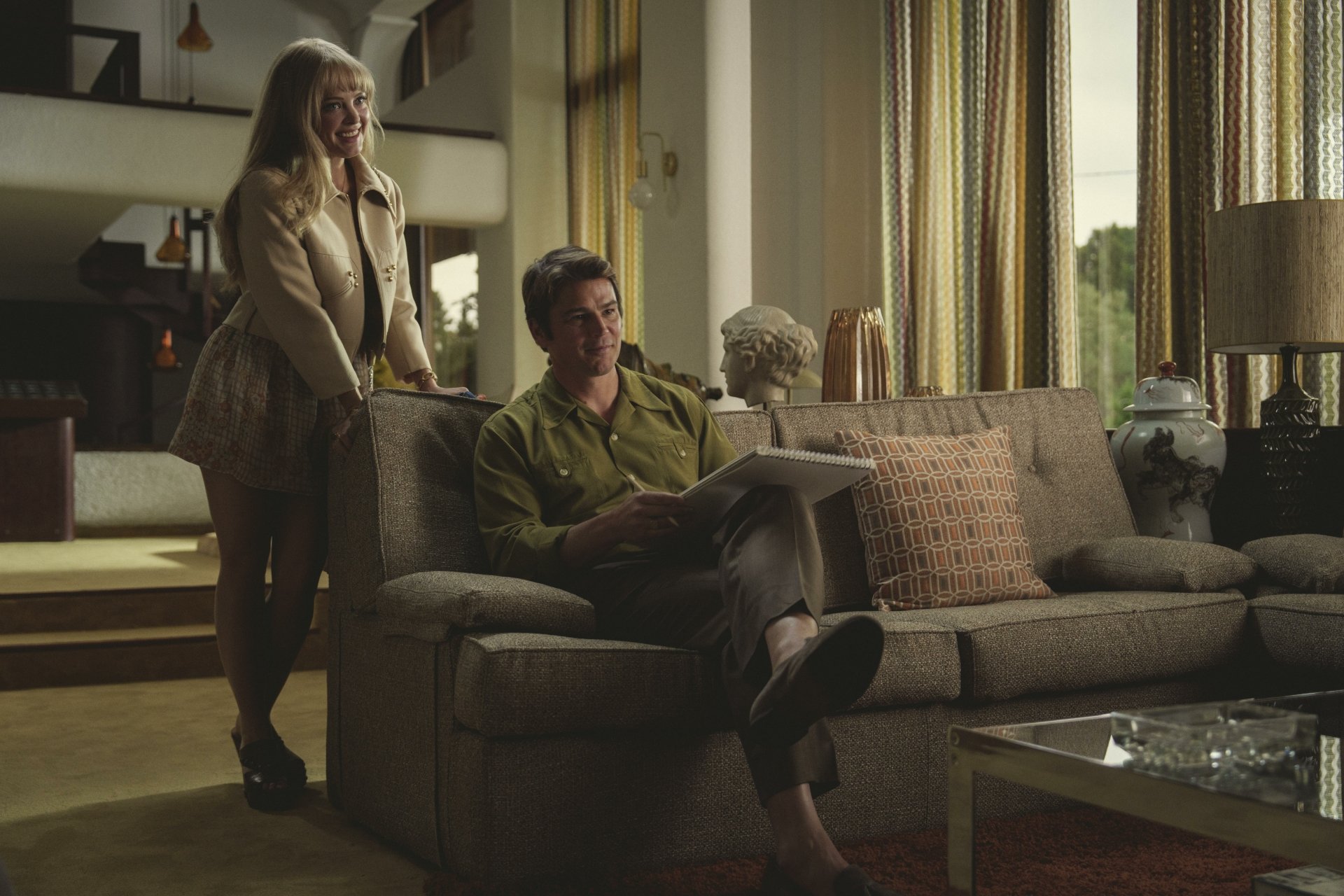 Auden Thornton and Josh Hartnett in a scene from the TV show Black Mirror, featuring a stylish living room with a sofa and decorative elements. HD desktop wallpaper.