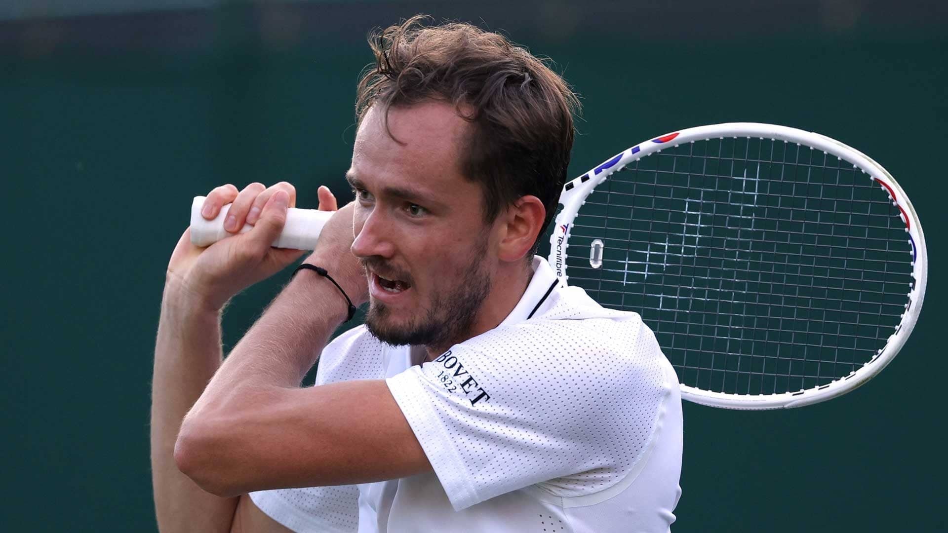 Daniil Medvedev prepares to hit a backhand during Wimbledon 2023, showcasing his focus and intensity in this dynamic tennis moment. HD wallpaper captures the spirit of sports.
