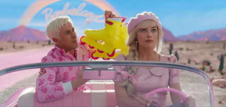 HD desktop wallpaper featuring two actors in colorful attire with a retro vibe, representing characters from Barbie (2023), with a vibrant desert backdrop.