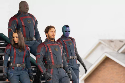 HD wallpaper of the Guardians of the Galaxy team with Star Lord, Nebula, and Drax in new uniforms against a backdrop of rooftops, promoting Guardians of the Galaxy Vol. 3.