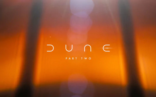 HD background featuring the movie title Dune: Part Two, set against an abstract warm-toned backdrop with soft lighting effects.
