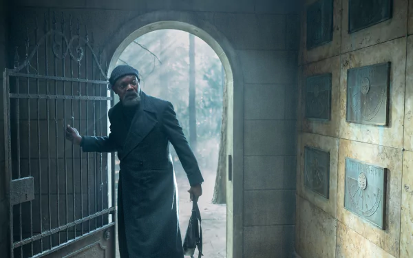 Man in a trench coat stepping through a wrought iron gate in a mysterious foggy setting, related to Secret Invasion as a HD desktop wallpaper background.