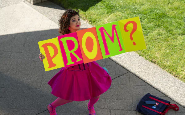 Young woman in a vibrant pink dress holding a colorful sign asking PROM? — Prom Pact theme HD desktop wallpaper and background.