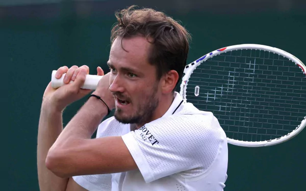 Daniil Medvedev prepares to hit a backhand during Wimbledon 2023, showcasing his focus and intensity in this dynamic tennis moment. HD wallpaper captures the spirit of sports.