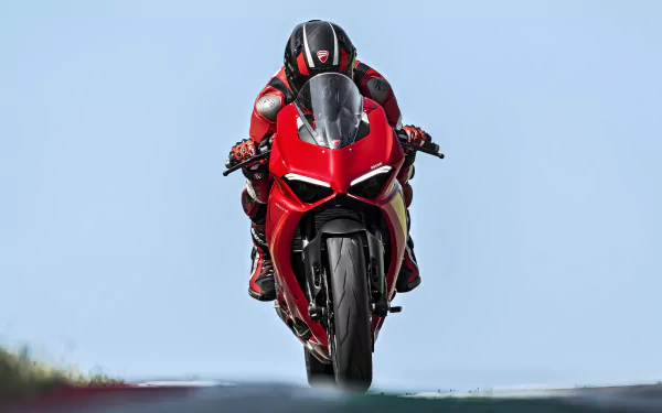Rider on a red Ducati Panigale V2 motorcycle leaning into a turn against a blurred background, in HD wallpaper format.
