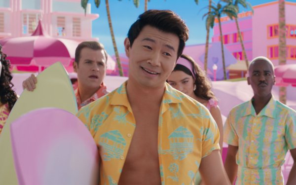 HD desktop wallpaper featuring a scene from the 2023 Barbie movie with Simu Liu wearing a vibrant yellow shirt, surrounded by cheerful characters in a colorful, whimsical setting.