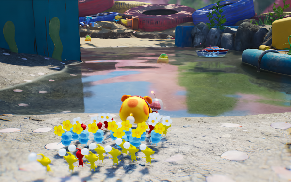 HD desktop wallpaper featuring a colorful scene from Pikmin 4 with a group of diverse Pikmin following a large yellow creature, set against an outdoor backdrop with water and toys.